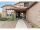 Charming front entrance featuring stone accents, a welcoming bench, and vibrant potted plants at 10653 E Lindner Cir, Mesa, AZ 85209