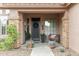 Inviting front porch with stone accents, potted plants, and a cozy bench seating area at 10653 E Lindner Cir, Mesa, AZ 85209