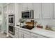 Kitchen with stainless steel appliances, white countertops, and sleek cooktop at 10653 E Lindner Cir, Mesa, AZ 85209