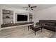 Living room with built-in shelving, neutral walls, and a ceiling fan at 10653 E Lindner Cir, Mesa, AZ 85209