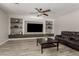 Living room with wood-look tile, built-in shelving, neutral walls, and ceiling fan at 10653 E Lindner Cir, Mesa, AZ 85209