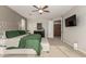 Comfortable main bedroom features a large television, a tufted ottoman, and an ensuite bathroom at 10653 E Lindner Cir, Mesa, AZ 85209
