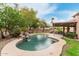Backyard pool featuring rock waterfall, lush landscaping, and covered patio, ideal for outdoor entertaining at 10653 E Lindner Cir, Mesa, AZ 85209
