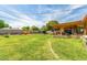 Spacious backyard featuring a covered patio, storage shed, and a lush lawn with mature trees at 1143 E 7Th St, Mesa, AZ 85203