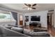 Cozy living room with hardwood floors, a comfortable gray sectional, and a ceiling fan at 1143 E 7Th St, Mesa, AZ 85203