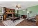 Cozy living room features a stone fireplace, wood floors, and a ceiling fan at 1143 E 7Th St, Mesa, AZ 85203