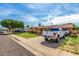 Street view of a charming brick home featuring a lush lawn, long driveway, and covered parking area for vehicles at 1143 E 7Th St, Mesa, AZ 85203