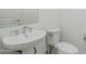 Half bathroom featuring a pedestal sink, commode, and large mirror at 11996 N Luckenbach St, Surprise, AZ 85388