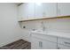 Laundry room with white cabinets, countertops, and a stainless steel sink at 11996 N Luckenbach St, Surprise, AZ 85388