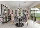Elegant dining room featuring modern light fixture, glass table, bar area, and access to the outdoor patio at 1303 W Cherrywood Dr, Queen Creek, AZ 85140