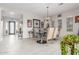 Airy dining room featuring modern chandelier, glass table, neutral color palette, and abundant natural light at 1303 W Cherrywood Dr, Queen Creek, AZ 85140