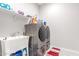 Functional laundry room equipped with modern washer and dryer, sink, and shelving for efficient laundry management at 1303 W Cherrywood Dr, Queen Creek, AZ 85140