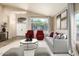 Staged living room with comfortable seating, neutral colors and large arched window for plenty of natural light at 1447 E Nighthawk Way, Phoenix, AZ 85048