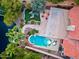 Aerial view of a backyard with a pool, fire pit, lounge area, well-manicured lawn, and access to a canal at 1457 W Bahia Ct, Gilbert, AZ 85233