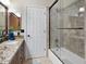 Bathroom featuring granite vanity, dark wood cabinetry, and a shower over tub with glass doors at 1457 W Bahia Ct, Gilbert, AZ 85233