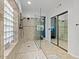 Bright bathroom featuring a glass shower, tile accents, and natural light through glass block window at 1457 W Bahia Ct, Gilbert, AZ 85233