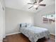 Bedroom featuring hardwood floors, ceiling fan, and bright windows showcasing rooftops and palm trees at 1457 W Bahia Ct, Gilbert, AZ 85233