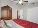 Bedroom featuring hardwood floors, ceiling fan, armoire, and closet with sliding doors at 1457 W Bahia Ct, Gilbert, AZ 85233