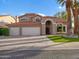 Two-story home featuring a red tile roof, arched entryway, and a spacious three-car garage at 1457 W Bahia Ct, Gilbert, AZ 85233