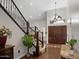 Bright entry foyer with a wooden staircase and a decorative chandelier at 1457 W Bahia Ct, Gilbert, AZ 85233