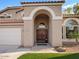 Inviting front entry with double wood doors, stone accents, and manicured lawn at 1457 W Bahia Ct, Gilbert, AZ 85233
