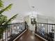 Hallway with hardwood floors, rod iron railing, and view to living area and kitchen at 1457 W Bahia Ct, Gilbert, AZ 85233