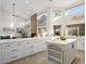 Spacious kitchen with white cabinets, quartz countertop, island with wine rack and adjacent to the living room at 1457 W Bahia Ct, Gilbert, AZ 85233