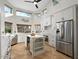 Bright kitchen features white cabinets, a stainless steel refrigerator, island with wine rack and great natural lighting at 1457 W Bahia Ct, Gilbert, AZ 85233