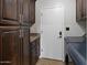 Laundry area with rich wood cabinetry and modern appliances for convenience at 1457 W Bahia Ct, Gilbert, AZ 85233