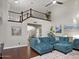 Living room with blue sectional sofa, high ceilings and a staircase to the second floor and hardwood floors at 1457 W Bahia Ct, Gilbert, AZ 85233