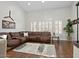 Bright living room with hardwood floors, plush sectional sofa, and plantation shutters at 1457 W Bahia Ct, Gilbert, AZ 85233