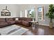 Cozy living room with hardwood floors, plush sectional sofa, and large windows for natural light at 1457 W Bahia Ct, Gilbert, AZ 85233