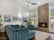 Comfortable living room with stone fireplace, high ceilings and a cozy blue sectional sofa set on hardwood floors at 1457 W Bahia Ct, Gilbert, AZ 85233