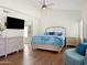 Main bedroom featuring a bed, lounge chair, hardwood floors and an ensuite bathroom at 1457 W Bahia Ct, Gilbert, AZ 85233