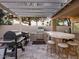 Outdoor kitchen features a built-in grill, smoker, and bar seating under a pergola at 1457 W Bahia Ct, Gilbert, AZ 85233