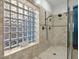 Detailed shot of a walk-in shower with glass block window and bronze shower fixtures at 1457 W Bahia Ct, Gilbert, AZ 85233