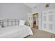 Neutral bedroom with a twin bed, soft white bedding and view into the ensuite bath and closet at 14575 W Mountain View Blvd # 11315, Surprise, AZ 85374