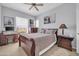 Bedroom with a traditional wood bed set and framed art, well-lit with natural light and fan at 14575 W Mountain View Blvd # 11315, Surprise, AZ 85374