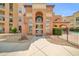 Inviting multi-story building featuring stucco walls, arched entryway, and manicured desert landscaping at 14575 W Mountain View Blvd # 11315, Surprise, AZ 85374