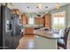 This kitchen features wood cabinets, stainless appliances and a center island with room for seating and a slider to the balcony at 14575 W Mountain View Blvd # 11315, Surprise, AZ 85374