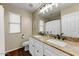 Bathroom boasts double sinks with granite countertops, a large mirror, and wood flooring at 15138 W Campbell Ave, Goodyear, AZ 85395