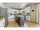 Well-lit kitchen with white cabinets, tile floors, granite countertops, and a center island at 15138 W Campbell Ave, Goodyear, AZ 85395