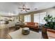 Open-concept living room with a ceiling fan, sofas, decorative rug, and access to the kitchen at 15138 W Campbell Ave, Goodyear, AZ 85395