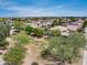 A wide aerial shot of the neighborhood showcasing lush trees, and a clear blue sky at 15138 W Campbell Ave, Goodyear, AZ 85395