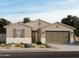 Charming single-story home features a two-car garage, neutral stucco, and a beautifully landscaped front yard at 15995 W Honeysuckle Dr, Surprise, AZ 85387