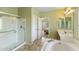 A bright bathroom with walk in shower, soaking tub, and doorway to bedroom at 16158 W Christy Dr, Surprise, AZ 85379