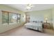 Comfortable bedroom with a ceiling fan and natural light from the large windows at 16158 W Christy Dr, Surprise, AZ 85379