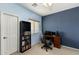 A blue bedroom with a desk, a window, and a built-in bookcase at 16158 W Christy Dr, Surprise, AZ 85379