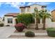 Charming home showcases stucco facade, red tile roof, and lush desert landscaping with palm trees at 16158 W Christy Dr, Surprise, AZ 85379