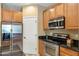 Modern kitchen with stainless steel appliances, granite counters, and wood cabinets at 16158 W Christy Dr, Surprise, AZ 85379